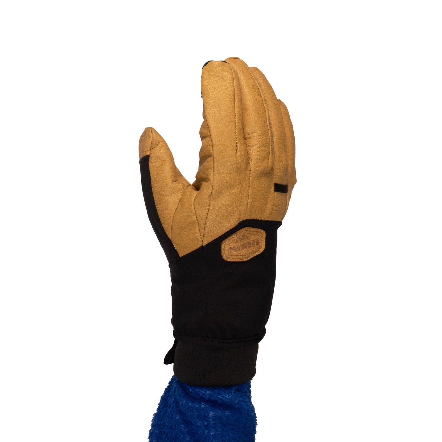 Against a white background, a hand is raised wearing the Loaf Glove by Mainers, a tan and black winter glove designed for warmth and protection.