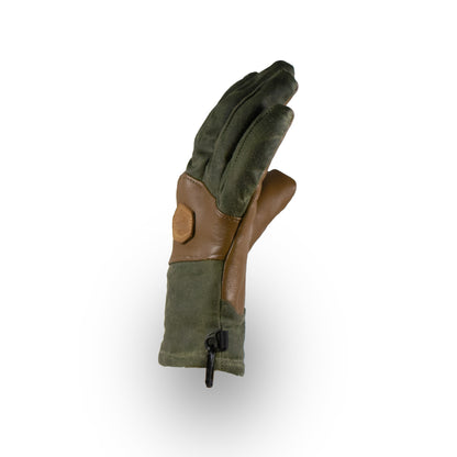 The MT Battie Glove by Mainers showcases a durable leather palm and an olive green and brown design. It stands against a white background, highlighting its waxed canvas finish for style and functionality.