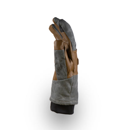 A Mainers Ragged MT Glove, versatile for winter adventures, stands upright against a plain white background with its brown and gray leather fingers slightly curled.