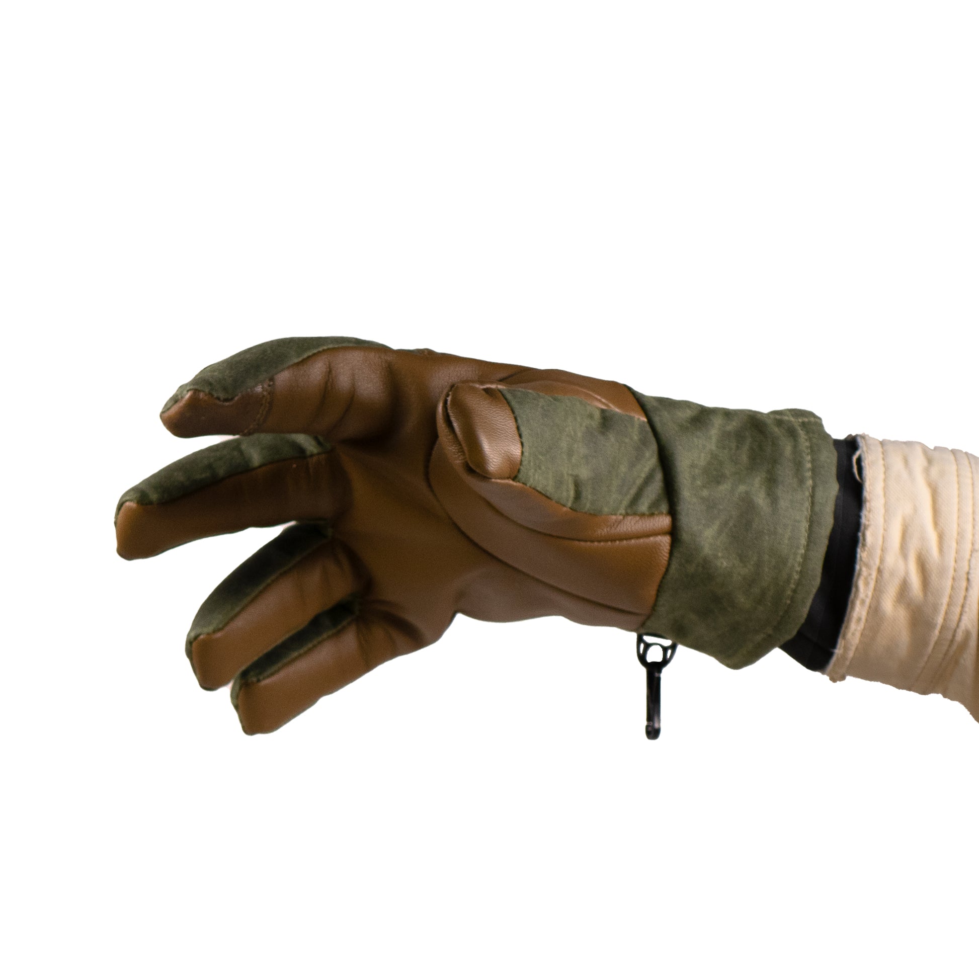 A close-up shows a hand wearing a brown and green Ragged MT Glove by Mainers, crafted from waxed canvas and leather, with the thumb, index, and middle fingers slightly curved.