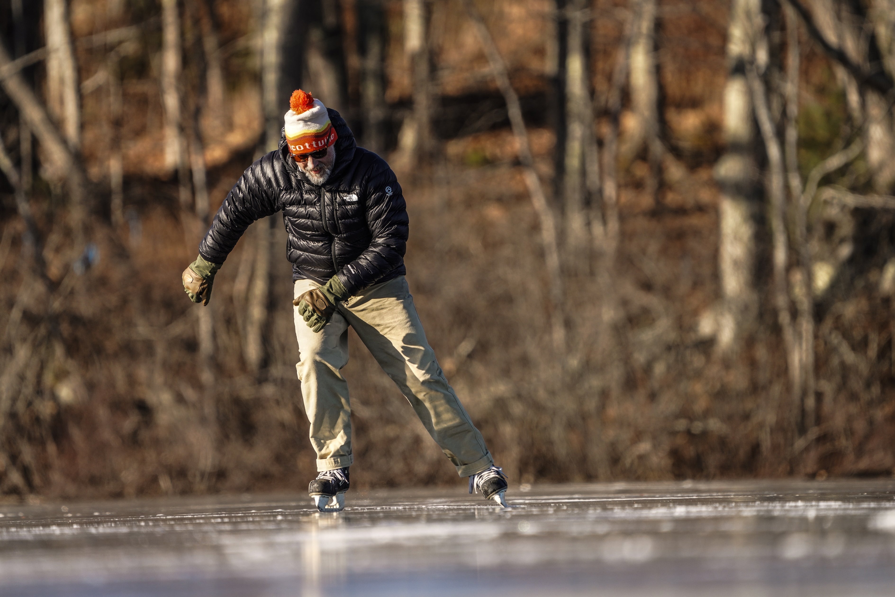 Man skating on pond wearing Mainers Ragged MT Glove in Moss/Coyote.